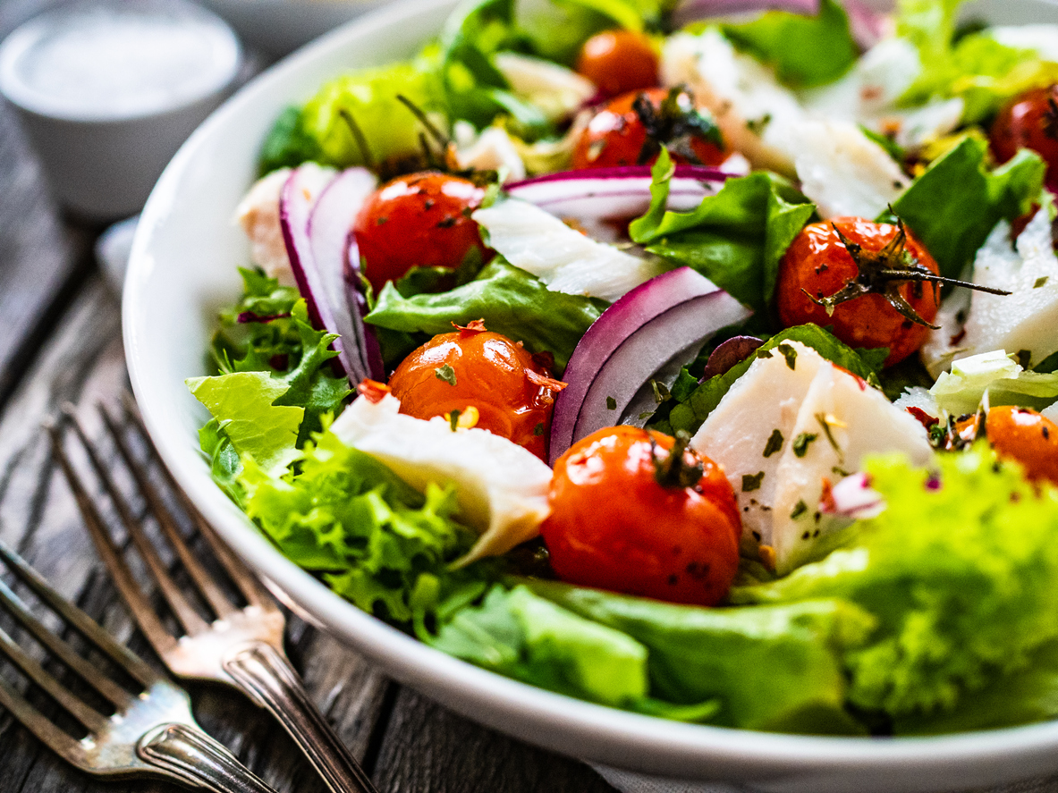Roast fish and vegetable salad on wooden background